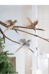 Dettaglio di quattro ornamenti natalizi a colibrì colorati con piume e paillettes lucide