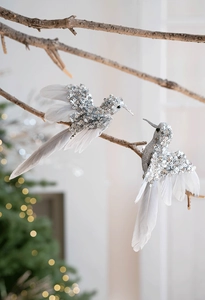 Dettaglio di uccellini decorativi glitterati con piume bianche per l'albero di Natale