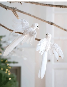 Dettaglio di uccellini decorativi in piume bianche con paillettes su rami secchi