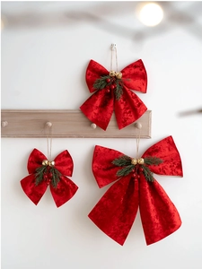 Three sizes of red velvet Christmas bows with golden bells and pine needles