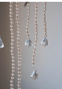 Macro view of crystal beaded chain with faceted clear acrylic tassels for wedding decor