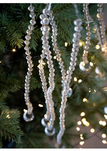 Close-up of clear acrylic beaded garland icicle drops hanging on a Christmas tree