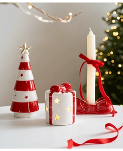 Keramik-Weihnachtsstern-Kerzenhalter und gestreifter Baum auf festlichem Tisch