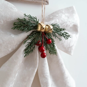 Velvet Christmas bow with golden bells and pine needles for holiday tree decoration