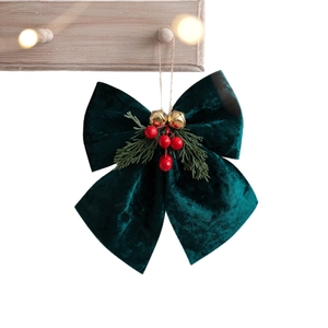 Green velvet Christmas bow with gold bells and red berries on a wooden hook