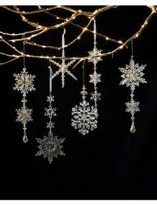Detailed view of clear acrylic snowflake ornaments hanging with warm LED string lights