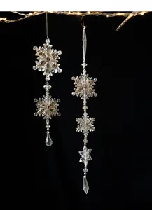 Detail of acrylic snowflake pendants with teardrop crystals and warm LED lighting