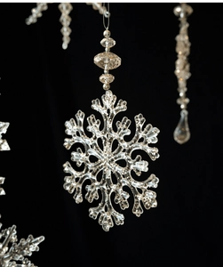 Detailed view of clear acrylic snowflake ornament with faceted beads on black background