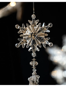 Macro shot of acrylic Christmas snowflake pendant with gold glitter and crystal beads