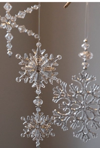 Close-up of clear acrylic snowflake ornament with gold glitter for Christmas decor