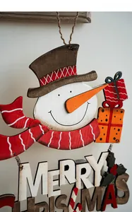 Détail d'un bonhomme de neige en bois peint multicouche avec signe Merry Christmas