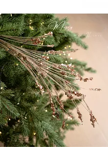 Nahaufnahme der roségoldenen Glitzerzweige an einem beleuchteten Weihnachtsbaum-Dekor
