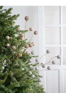 Detailed view of champagne gold and silver glitter berries on festive Christmas tree branches