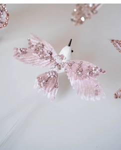 Close-up of pink velvet decorative bird with sparkling sequins and pearl embroidery