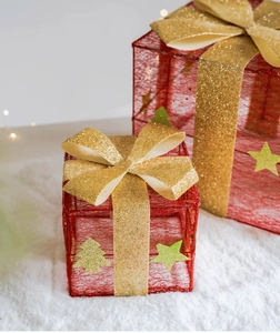 Dettaglio di scatole regalo di Natale rosse con nastri dorati sulla neve bianca