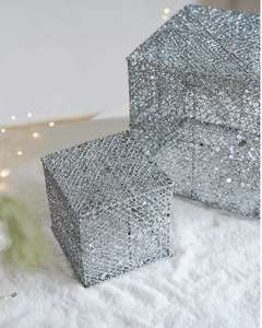 Dettaglio di scatole regalo in rete argentata glitterata con sfondo festivo di neve invernale
