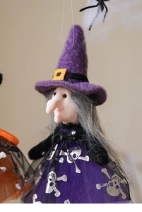 Detailed close-up of a Halloween witch ornament with a purple felt hat and mesh skirt
