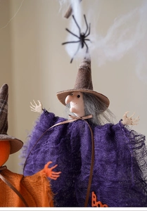 Close-up of a Halloween witch plush with purple mesh dress and Boo lettering detail