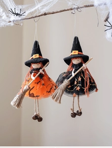Detail von Halloween-Hexenanhängern mit Tüllröcken und Minibesen an einem Zweig