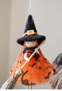 Detail der Halloween-Hexenpuppe mit orangem Netzrock, Fledermausdruck und Holzbesen