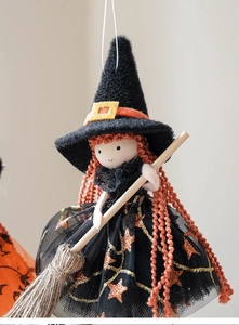 Detail einer Halloween Hexenpuppe mit orangefarbenem Haar, Netzrock und Holzbesen Deko