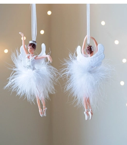 Close-up of white ballerina ornament with feather skirt and crown in festive lighting