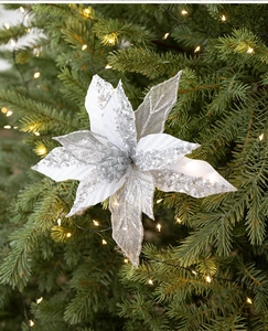 Detailopname van een zilveren kerstbloem met pailletten op een boom met LED-lampjes