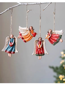 Close-up of four vintage resin Christmas angel ornaments hanging on white branches