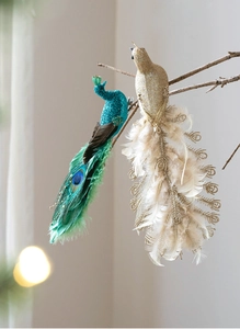 Close-up of artificial peacock and bird ornaments with feathers on tree branches