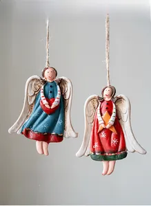 Detail of two resin Christmas angel ornaments with red heart and gold star motifs