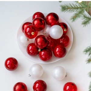 Close-up of red and white Christmas baubles in a white plate with pine branches
