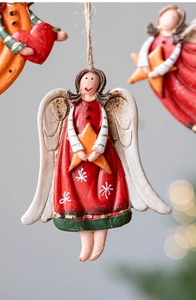 Close-up of hand-painted resin Christmas angel ornament with red dress and star