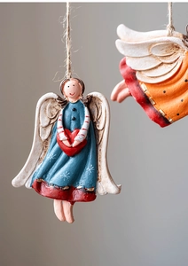 Close-up of vintage resin Christmas angel ornaments with hand-painted heart and wings
