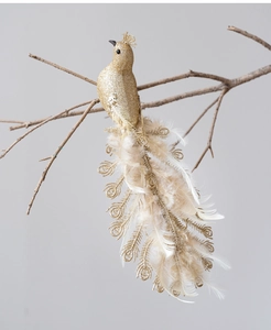 Detail of glittery gold peacock Christmas ornament with white feathers on tree branch