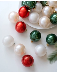 Close-up of assorted red glitter, green glazed, and pearl white Christmas ornaments