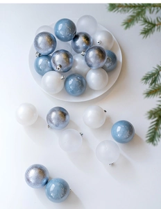 Close-up of 6cm blue and silver Christmas balls with glitter and matte finishes on a white tray