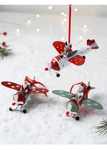 Detailed view of three painted iron Christmas airplane ornaments with festive characters
