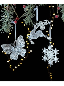 Close-up of transparent acrylic Christmas angel ornaments with silver glitter and white ribbons