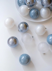 Flat lay of blue and silver Christmas balls with matte and glitter finishes