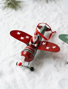 Macro detail of red and green metal vintage plane ornament with Santa Claus figure