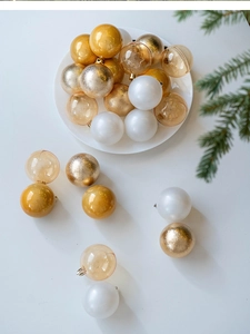 Close-up of elegant gold and champagne Christmas ornaments on a minimalist festive tray