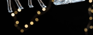 Detail of transparent acrylic reindeer ornament with silver glitter on black background