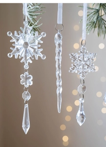 Detailed view of clear acrylic Christmas icicles and snowflake ornaments with white ribbons