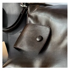 Detail view of coffee brown faux leather handbag with textured flap pocket and button