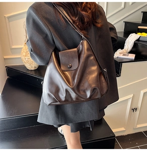 Detail of dark brown cloud bag with textured pleats and magnetic flap for women