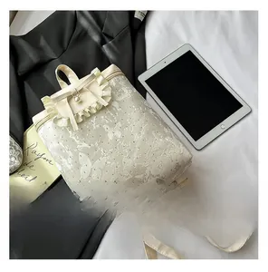 Detail of cream backpack with lace trim butterfly print and bow handle on fabric