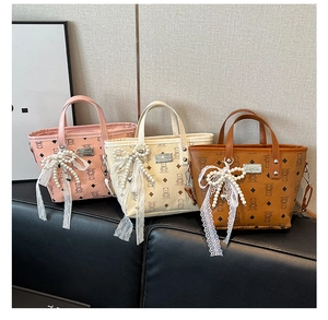 Détails de trois sacs seaux en cuir avec motifs d'ours, nœuds et breloques perles