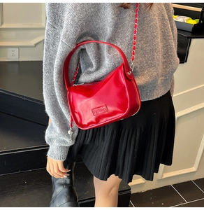 Détail du sac à main en cuir verni rouge avec gaufrage Fashion et chaîne en métal