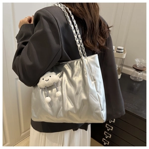 Close-up of metallic silver quilted tote bag with braided handles and cloud charm detail