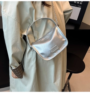 Détail du sac bandoulière argenté métallisé avec étiquette mode et bandoulière chaîne